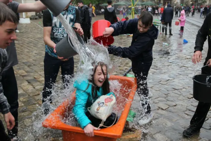 Люди весело поливають один одного